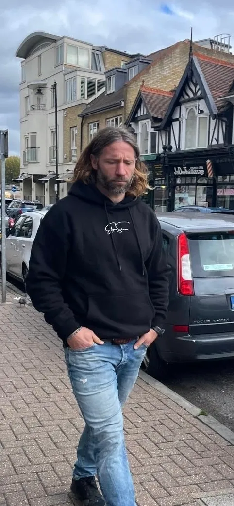 Man walking on a city street sidewalk.