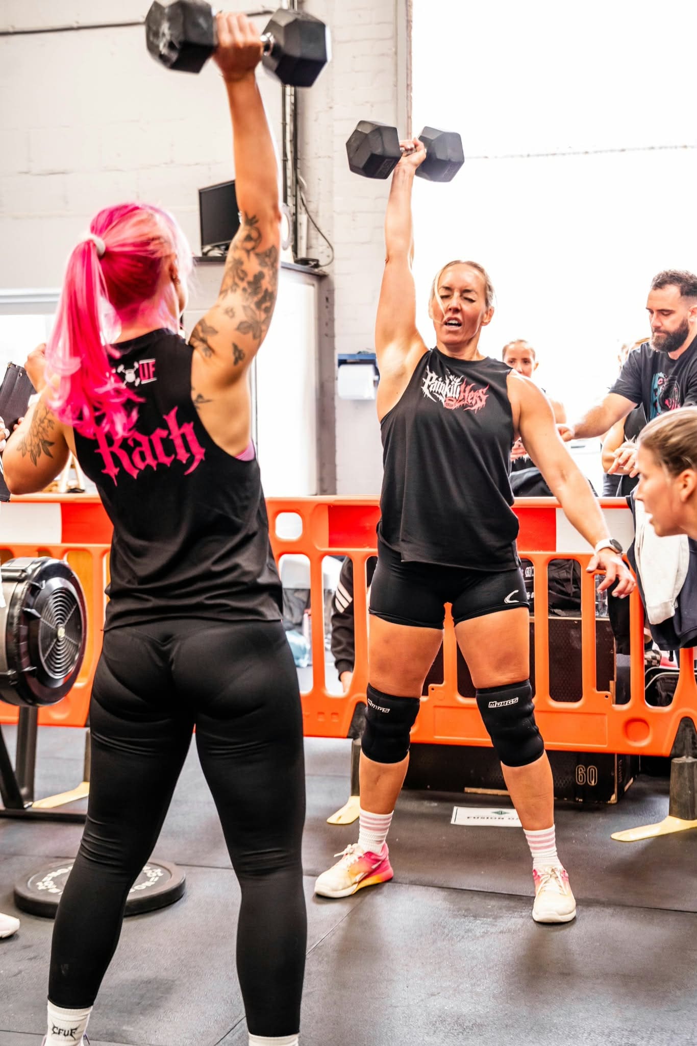 Two women lifting weights during training