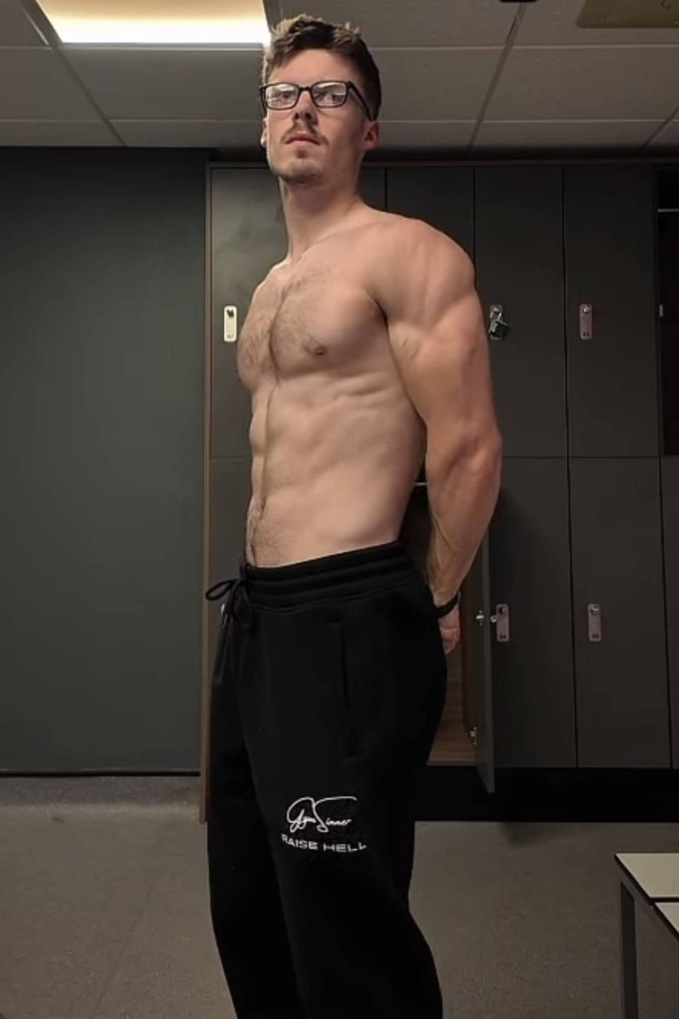 Fitness model posing in gym locker room
